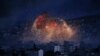 FILE - In this Oct. 20, 2014 file photo, thick smoke and flames erupt from an airstrike by the U.S.-led coalition in Kobani, Syria, as seen from a hilltop on the outskirts of Suruc, at the Turkey-Syria border. For Syrians marking seven years of war…
