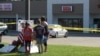 Zach, Zoe and Melissa Cates add to a makeshift memorial near the scene of a shooting at a Armed Forces Career Center/National Guard recruitment office in Chattanooga, Tennessee, July 16, 2015.