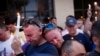 Paul Cox, right, leans on the shoulder of Brian Sullivan, as they observe a moment of silence during a vigil for a fatal shooting at an Orlando nightclub, June 12, 2016, in Atlanta.