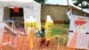 FILE - Health workers walk with a boy suspected of having been infected with the Ebola virus, at an Ebola treatment center in Beni, eastern DRC, Sept 9, 2018.