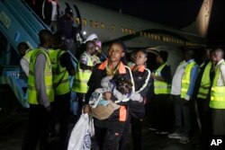 FILE - Nigerian returnees from Libya disembark from a plane upon arrival at the Murtala Muhammed International Airport in Lagos, Nigeria, Dec. 5, 2017.