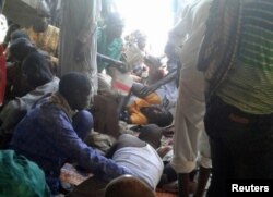 Injured people are comforted at the site after a bombing attack of an internally displaced persons camp in Rann, Nigeria, Jan. 17, 2017.
