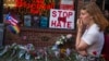 A woman cries and holds flowers in front of a makeshift memorial to remember the victims of a mass shooting in Orlando, Fla., in New York, Sunday, June 12, 2016