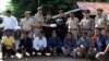 The seven Rohingya men to be deported sit as Indian and Myanmar security officials exchange documents before their deportation on India-Myanmar border at Moreh in the northeastern state of Manipur, India, Oct. 4, 2018.