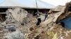 People walk around a destroyed house in Karakocan province of southeastern city Elazig, 08 Mar 2010