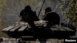 Anggota pasukan Ukraina berada di atas tank yang melaju menuju garis depan pertempuran di Bakhmut, Ukraina, pada 12 Mei 2023. (Foto: Reuters/Sofiia Gatilova)