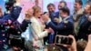 Ukrainian comedian and presidential candidate Volodymyr Zelenskiy, center right, and his wife Olena Zelenska, center left, greet their supporters at his headquarters in Kyiv, Ukraine, Sunday, April 21, 2019. 