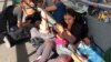 Migrantes de Guatemala, Cuba, Honduras y El Salvador hacen fila en el Puente Internacional de Santa Fe, El Paso en Texas, para solicitar asilo político en Estados Unidos.