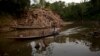 Un bote pasa frente a desechos de madera arrojados a un río en Ciudad Constitución, Perú, el 27 de octubre de 2015.