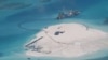 FILE - In this Feb. 25, 2014 file photo taken by surveillance planes and released May 15 by the Philippine Department of Foreign Affairs, a Chinese vessel, top center, is used to expand structures and land on the Johnson Reef, called Mabini by the Philippines and Chigua by China, at the Spratly Islands in the South China Sea, Philippines. 