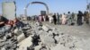 Afghan security forces and civilians walk at the site of a suicide attack in Lashkar Gah, capital of Helmand province, June 4, 2015. 