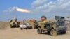 FILE - Iraqi government forces and allied militias fire weaponry from a position in the northern part of Diyala province as they conduct an assault to retake the city of Tikrit from the Islamic State group March 2, 2015. On Monday they launched a similiar assault on Fallujah.