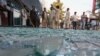 After a bomb explodes in a central business district of Kabul, Afghanistan, onlookers gather at the scene, July 13, 2015.