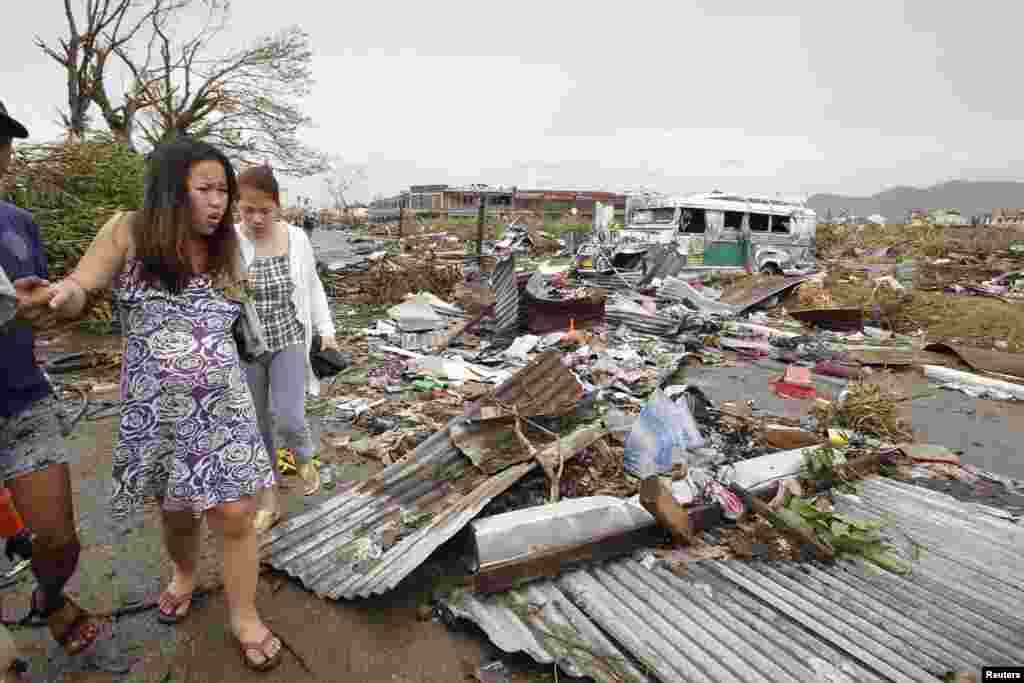 Một phụ nữ mang thai đi qua đống đổ nát sau Siêu bão Haiyan tại thành phố Tacloban, miền trung Philippines, ngày 9/11/2013.