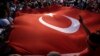 Protesters wave a large Turkish flag during an anti-coup rally in Taksim Square in Istanbul, July 25, 2016. 