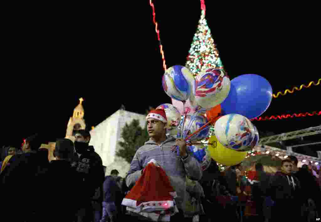 A Palestinian vendor sells balloons and Christmas hats at Manger Square, outside the Church of the Nativity, the site revered as the birthplace of Jesus, on Christmas eve in the West Bank town of Bethlehem, December 24, 2012.