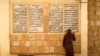 FILE - A displaced woman from the minority Yazidi sect, who fled violence in the Iraqi town of Sinjar, worships at their main holy temple in Lalish in Shikhan, Sept. 20, 2014. 