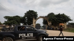 A police truck is stationed outside the University of Abuja Staff Quarters gate where unknown gunmen kidnapped two university professors, lecturers and their family members in Abuja, Nigeria, Nov. 2, 2021.