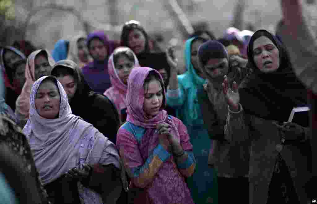 Pakistani women pray during an outdoor Mass on Christmas Day, in a Christian neighborhood in Islamabad, Pakistan, December 25, 2012.