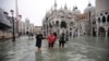 Personas vadean a través del agua en la inundada Plaza de San Marcos en Venecia, Italia, el miércoles 13 de noviembre de 2019. El nivel de marea alta alcanzó 187 centímetros (74 pulgadas) el martes 12 de noviembre de 2019, lo que significa que más del 85% de la ciudad se inundó.